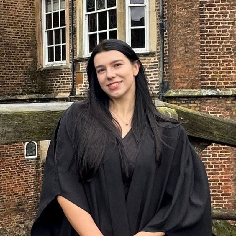 Viktoriia Astafieva in academic dress on the Mathematical Bridge, Cambridge